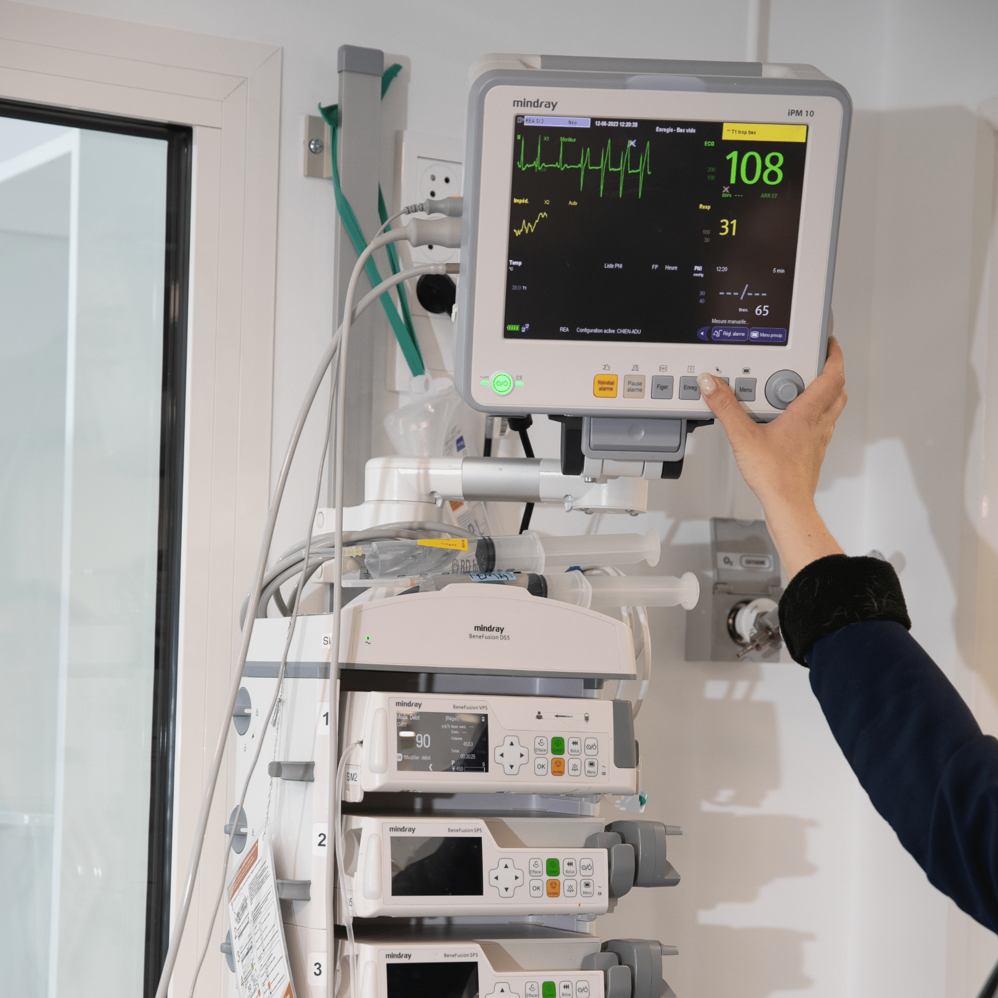 Équipement médical en milieu vétérinaire comprenant un moniteur de surveillance des constantes vitales et plusieurs pompes à perfusion, utilisé pour le suivi des patients en soins intensifs.